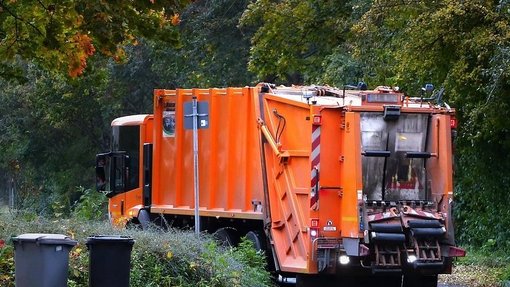 Orangenes Müllauto am Waldesrand