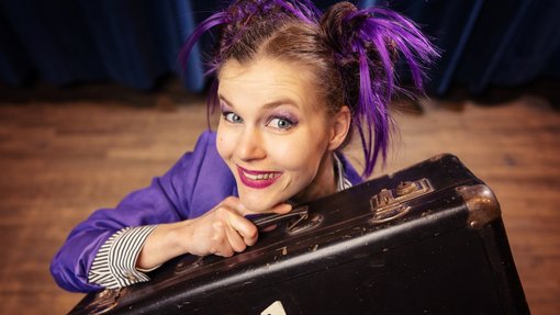 Zauberkünstlerin mit einem Koffer in der Hand