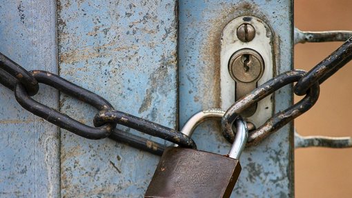 Kette mit Vorhängeschloss an Tor