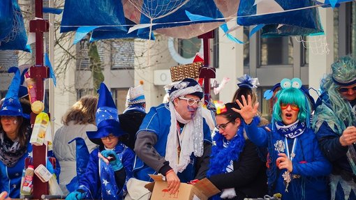 Blau verkleidete Personen auf einem Umzugswagen